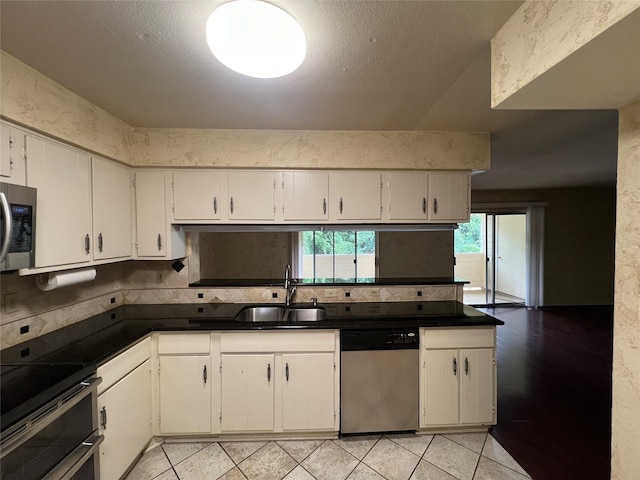 14515 Wunderlich Dr Unit 708, Houston, TX 77069 - kitchen featuring appliances with stainless steel finishes, tasteful backsplash, dark countertops, white cabinetry, and light tile patterned floors