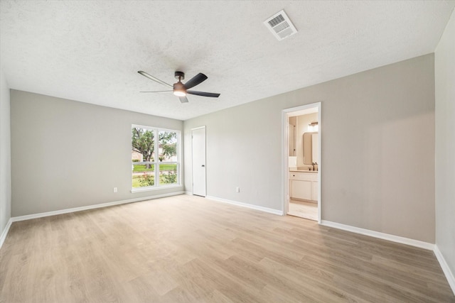 3114 Wagon Trail Dr, Sugar Land, TX 77479 - unfurnished bedroom with light wood-style floors, a textured ceiling, connected bathroom, a ceiling fan, and a closet
