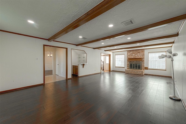 2510 Wind Fall Ln, Sugar Land, TX 77479 - unfurnished living room featuring a textured ceiling, beam ceiling, wood finished floors, a brick fireplace, and recessed lighting