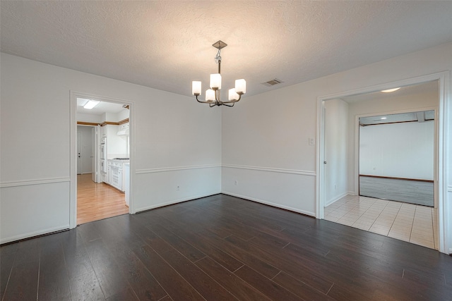 2510 Wind Fall Ln, Sugar Land, TX 77479 - spare room featuring a chandelier, wood finished floors, and a textured ceiling