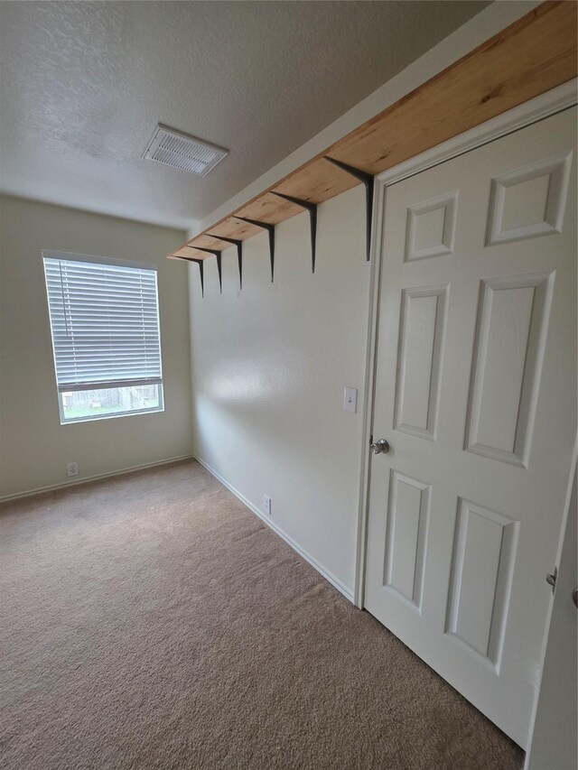 9714 Coyote Creek Dr, Houston, TX 77095 - carpeted empty room featuring baseboards and a textured ceiling