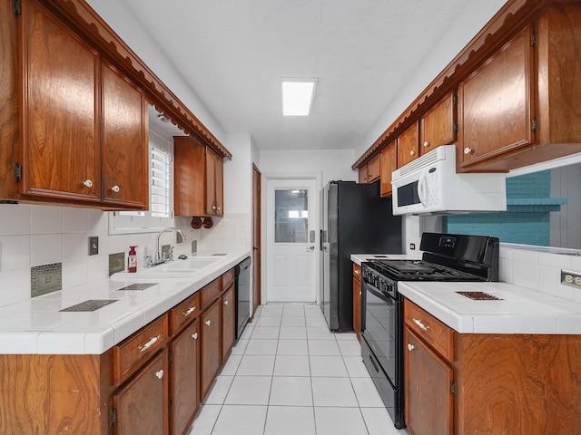 1406 Chippawa Ln, Pasadena, TX 77504 - kitchen with black range, white microwave, tasteful backsplash, and light tile patterned floors