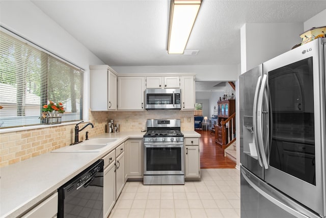 27 Camberwell Ct, Spring, TX 77380 - kitchen featuring appliances with stainless steel finishes, light countertops, tasteful backsplash, and light tile patterned flooring