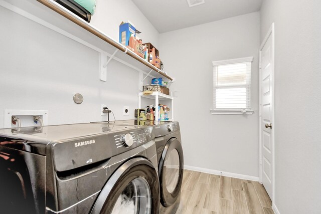 8419 Sunset Horizon Dr, Baytown, TX 77521 - laundry room with washer and dryer and light wood-style floors