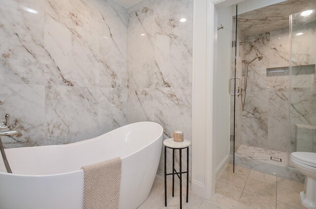 987 S Post Oak Ln, Houston, TX 77056 - bathroom featuring a marble finish shower, a freestanding bath, and tile walls