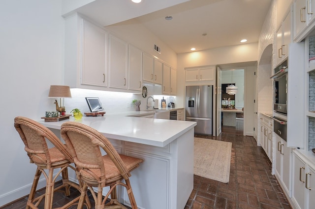 987 S Post Oak Ln, Houston, TX 77056 - kitchen with stainless steel appliances, tasteful backsplash, a peninsula, light countertops, and a warming drawer