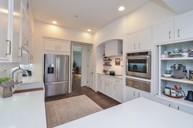 987 S Post Oak Ln, Houston, TX 77056 - kitchen featuring stainless steel appliances, a warming drawer, light countertops, white cabinets, and decorative backsplash
