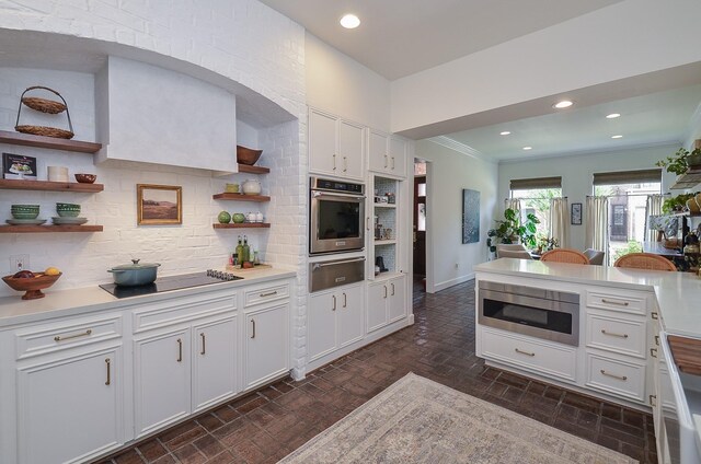 987 S Post Oak Ln, Houston, TX 77056 - kitchen with stainless steel appliances, a warming drawer, open shelves, tasteful backsplash, and brick patterned floors