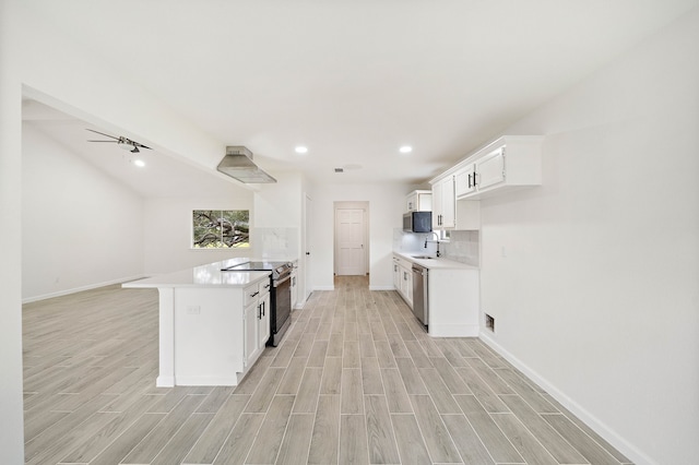 10219 Weldon Rd, Freeport, TX 77541 - kitchen featuring appliances with stainless steel finishes, light wood-type flooring, a peninsula, light countertops, and white cabinets