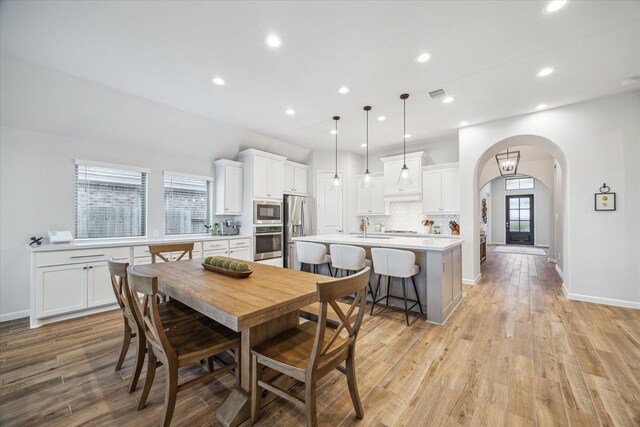 1523 Carson Field Ln, Richmond, TX 77469 - dining room with arched walkways, light wood finished floors, and recessed lighting