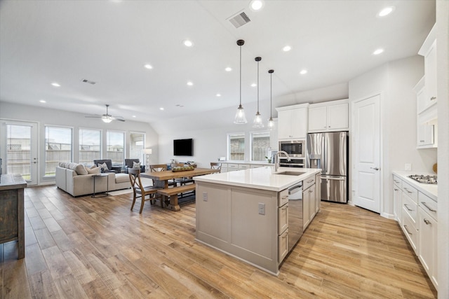1523 Carson Field Ln, Richmond, TX 77469 - kitchen with stainless steel appliances, a kitchen island with sink, light countertops, light wood-style flooring, and recessed lighting