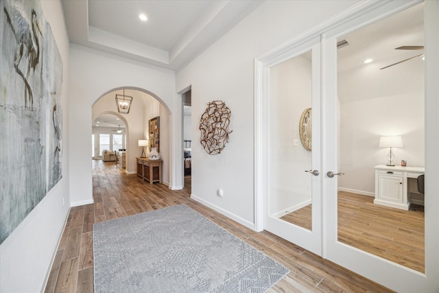 1523 Carson Field Ln, Richmond, TX 77469 - foyer featuring arched walkways, wood finished floors, ceiling fan, french doors, and a tray ceiling