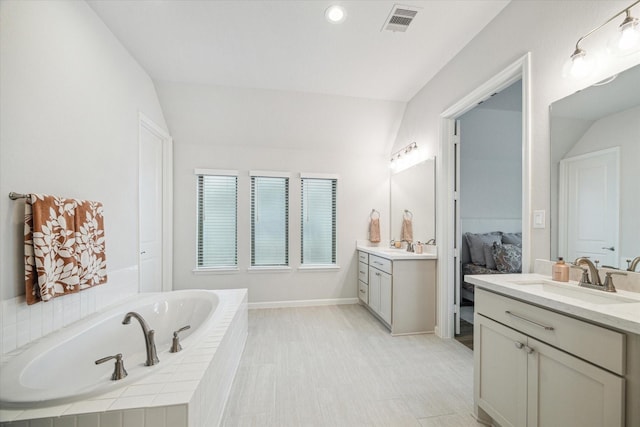 1523 Carson Field Ln, Richmond, TX 77469 - ensuite bathroom with two vanities, a bath, lofted ceiling, and recessed lighting