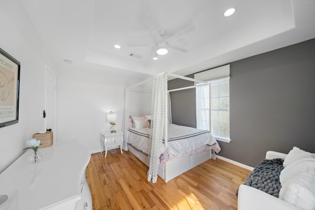 710 93rd St, Galveston, TX 77554 - bedroom featuring light wood finished floors, recessed lighting, a ceiling fan, a tray ceiling, and baseboards