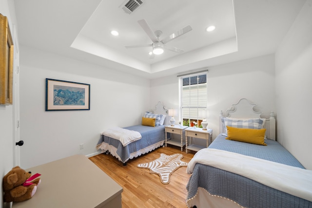 710 93rd St, Galveston, TX 77554 - bedroom with a raised ceiling, light wood-style flooring, a ceiling fan, and recessed lighting