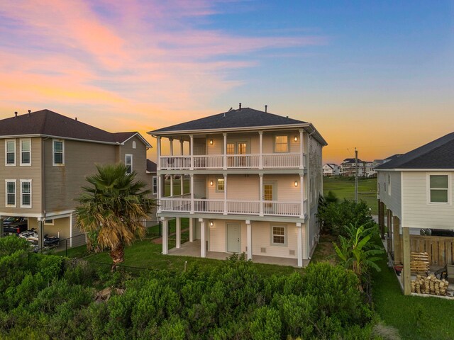 710 93rd St, Galveston, TX 77554 - back of property at dusk with a balcony and a patio