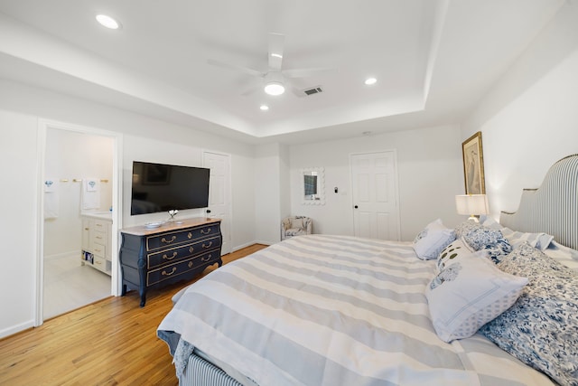 710 93rd St, Galveston, TX 77554 - bedroom featuring a raised ceiling, light wood-type flooring, recessed lighting, ceiling fan, and ensuite bathroom