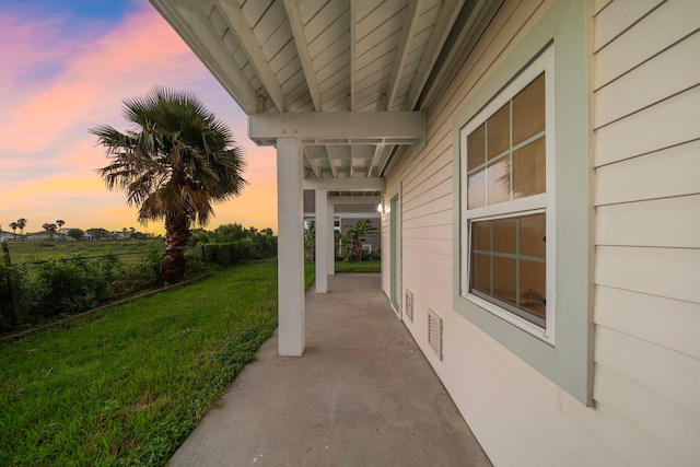 710 93rd St, Galveston, TX 77554 - patio terrace at dusk featuring a lawn