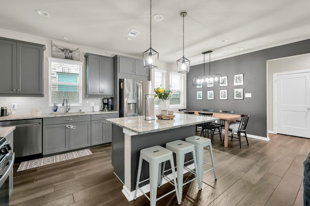 12330 Castano Creek Dr, Humble, TX 77346 - kitchen with stainless steel appliances, gray cabinetry, dark wood-type flooring, a breakfast bar area, and recessed lighting