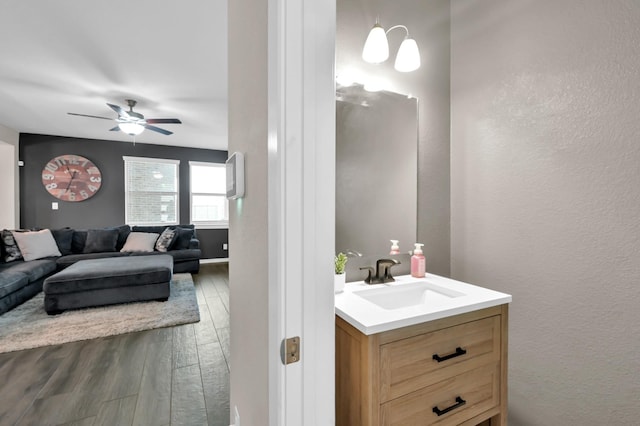 12330 Castano Creek Dr, Humble, TX 77346 - bathroom featuring vanity, wood finished floors, ceiling fan, and a textured wall