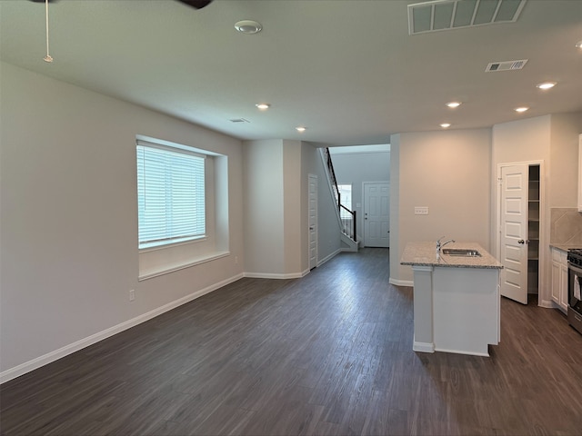 13308 Burbot Dr, Conroe, TX 77384 - kitchen with dark wood-style floors, recessed lighting, light stone countertops, open floor plan, and white cabinets