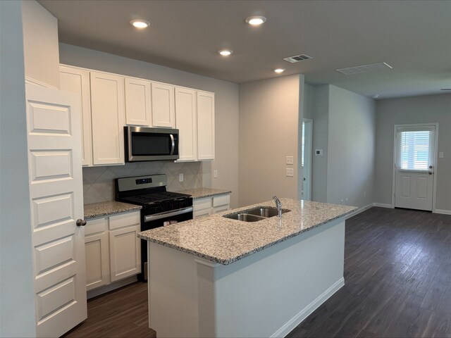 13308 Burbot Dr, Conroe, TX 77384 - kitchen with appliances with stainless steel finishes, white cabinetry, backsplash, light stone countertops, and recessed lighting