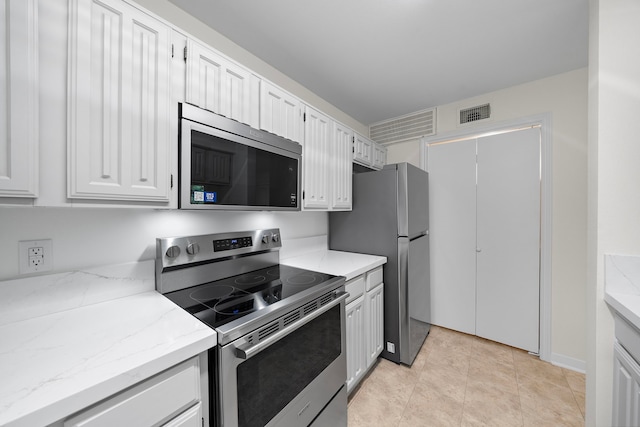 3500 Tangle Brush Dr Unit 28, The Woodlands, TX 77381 - kitchen featuring appliances with stainless steel finishes, white cabinetry, and light stone counters