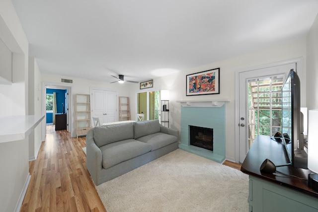 3500 Tangle Brush Dr Unit 28, The Woodlands, TX 77381 - living area with a ceiling fan, light wood finished floors, and a brick fireplace
