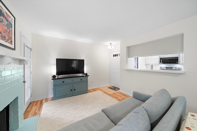 3500 Tangle Brush Dr Unit 28, The Woodlands, TX 77381 - living room with light wood-type flooring and a brick fireplace