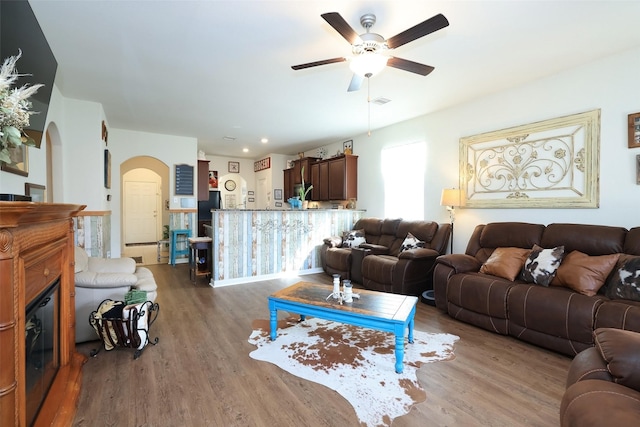 25106 Dickens Dr, Magnolia, TX 77355 - living room featuring arched walkways, ceiling fan, and wood finished floors