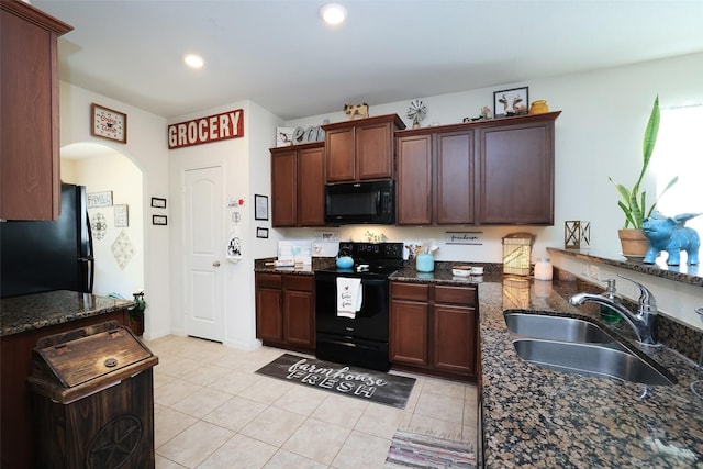 25106 Dickens Dr, Magnolia, TX 77355 - kitchen with black appliances, dark stone countertops, arched walkways, light tile patterned floors, and recessed lighting