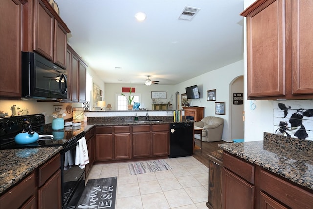 25106 Dickens Dr, Magnolia, TX 77355 - kitchen with black appliances, arched walkways, ceiling fan, open floor plan, and a peninsula