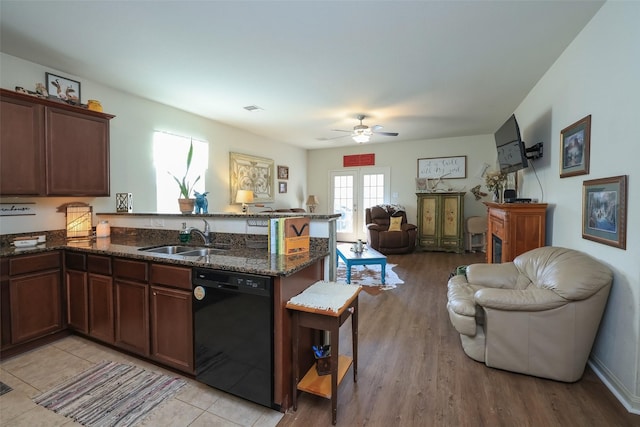 25106 Dickens Dr, Magnolia, TX 77355 - kitchen featuring black dishwasher, a peninsula, open floor plan, ceiling fan, and dark stone countertops