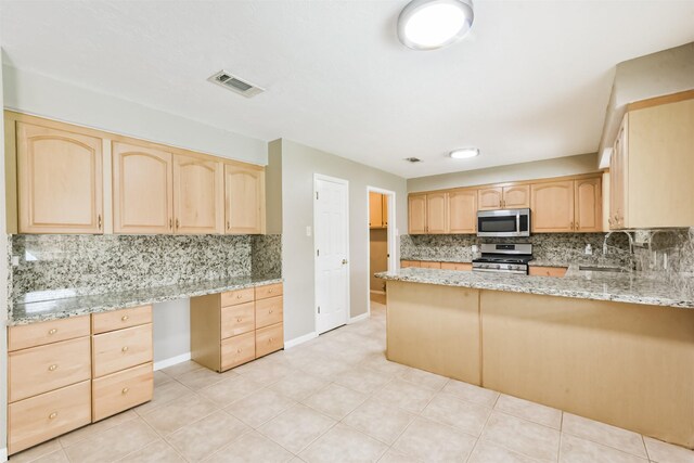 3313 Park Dale Dr, Deer Park, TX 77536 - kitchen featuring stainless steel appliances, light brown cabinets, built in desk, and decorative backsplash