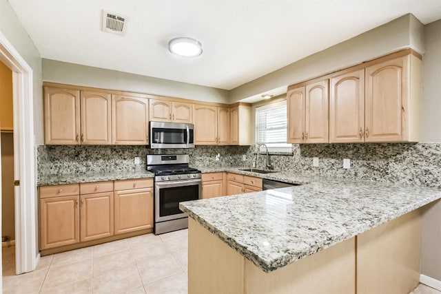 3313 Park Dale Dr, Deer Park, TX 77536 - kitchen featuring stainless steel appliances, light brown cabinetry, a peninsula, backsplash, and light stone countertops