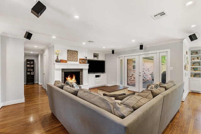 1011 Martin St, Houston, TX 77018 - living area with french doors, ornamental molding, wood finished floors, recessed lighting, and a brick fireplace