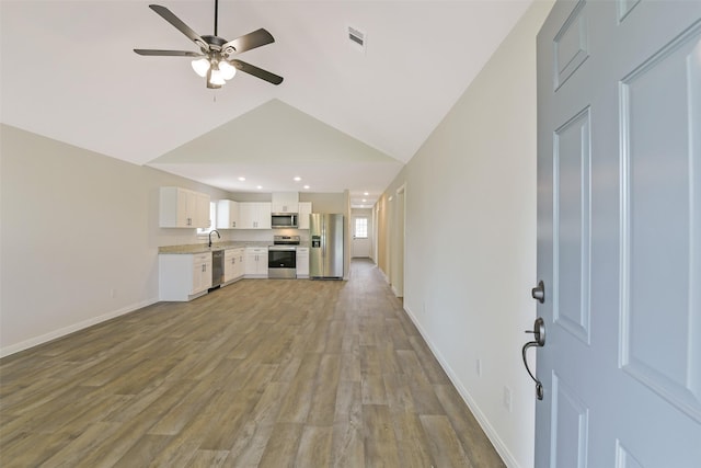 405 3rd St, Hempstead, TX 77445 - unfurnished living room featuring vaulted ceiling, ceiling fan, light wood finished floors, and recessed lighting