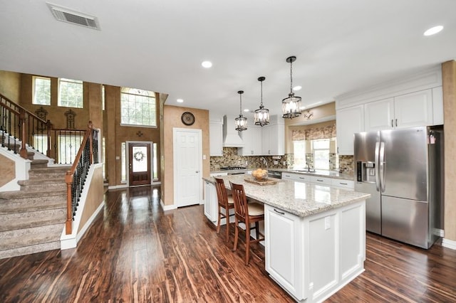 30103 Canyon Branch Ct, Spring, TX 77386 - kitchen featuring stainless steel refrigerator with ice dispenser, a kitchen island, custom range hood, dark wood-style flooring, and white cabinets