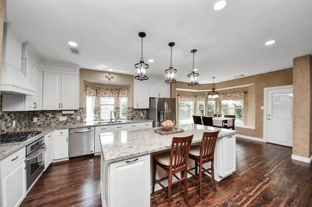 30103 Canyon Branch Ct, Spring, TX 77386 - kitchen with appliances with stainless steel finishes, dark wood-style flooring, plenty of natural light, an island with sink, and recessed lighting