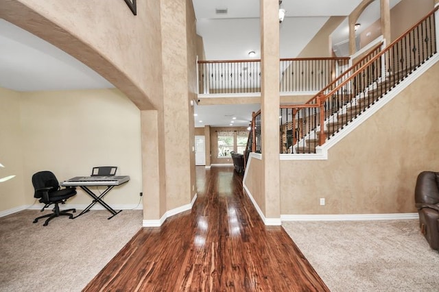 30103 Canyon Branch Ct, Spring, TX 77386 - foyer entrance featuring wood finished floors, a high ceiling, arched walkways, stairway, and carpet flooring