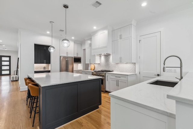 5216 Chestnut St, Bellaire, TX 77401 - kitchen featuring high quality appliances, a kitchen island, light countertops, backsplash, and recessed lighting