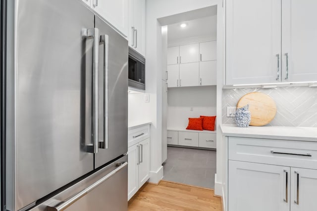 5216 Chestnut St, Bellaire, TX 77401 - kitchen featuring appliances with stainless steel finishes, white cabinets, decorative backsplash, light countertops, and recessed lighting