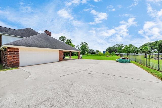 3515 Kansas St, Fresno, TX 77545 - view of home's exterior with a chimney, concrete driveway, brick siding, and roof with shingles