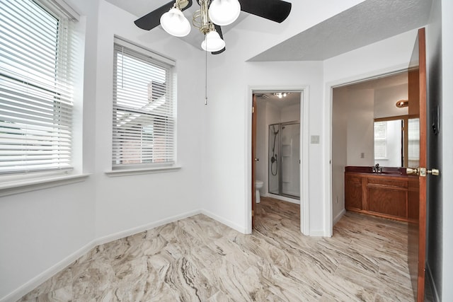 3515 Kansas St, Fresno, TX 77545 - unfurnished bedroom featuring light marble finish flooring, ceiling fan, and ensuite bath