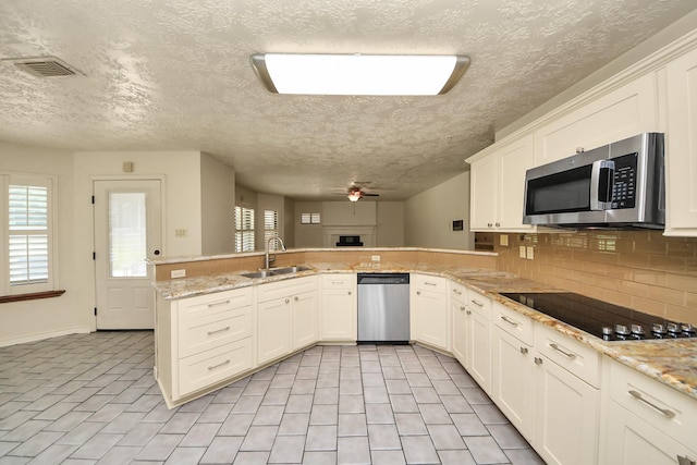 3515 Kansas St, Fresno, TX 77545 - kitchen featuring appliances with stainless steel finishes, a peninsula, plenty of natural light, ceiling fan, and a textured ceiling
