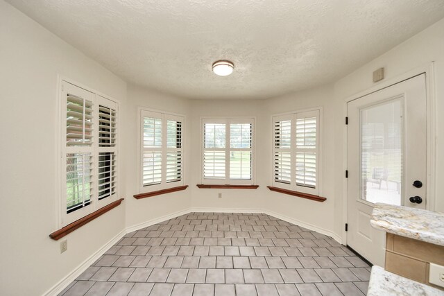 3515 Kansas St, Fresno, TX 77545 - unfurnished dining area with a textured ceiling and baseboards
