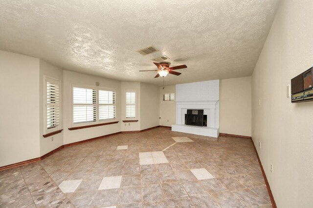 3515 Kansas St, Fresno, TX 77545 - unfurnished living room featuring a textured ceiling, ceiling fan, and a large fireplace