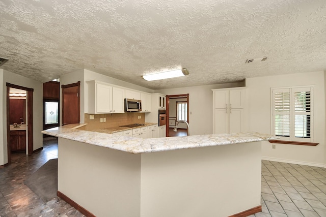 3515 Kansas St, Fresno, TX 77545 - kitchen with stainless steel appliances, tile patterned floors, white cabinetry, a peninsula, and a textured ceiling