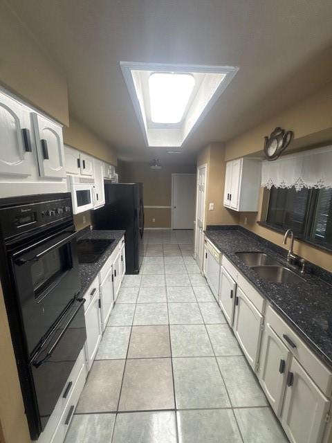 20114 Foxchester Ln, Humble, TX 77338 - kitchen featuring black appliances, light tile patterned flooring, white cabinetry, and dark stone counters