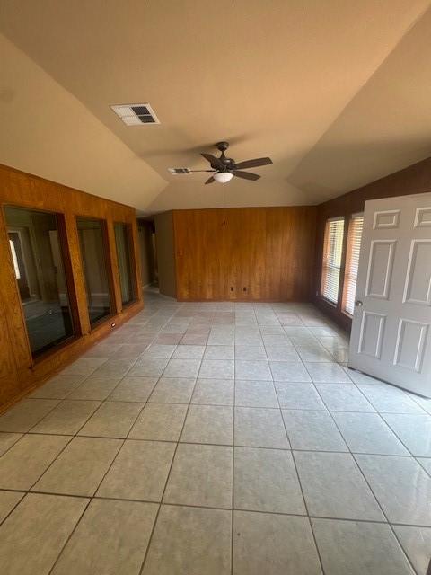 20114 Foxchester Ln, Humble, TX 77338 - unfurnished room featuring lofted ceiling, wooden walls, ceiling fan, and light tile patterned floors